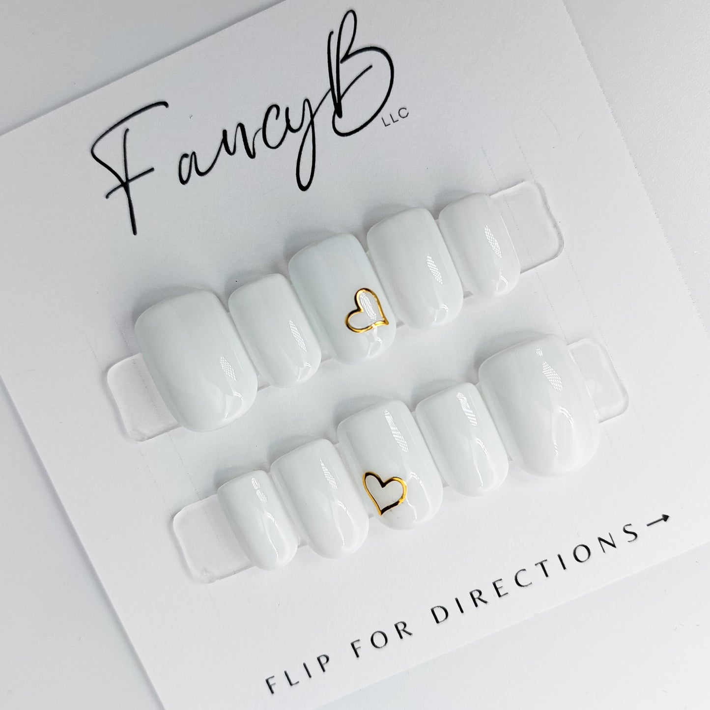 white press on nails with gold hearts, simple nail designs by fancyb nails. Shown in short squoval short square shape.