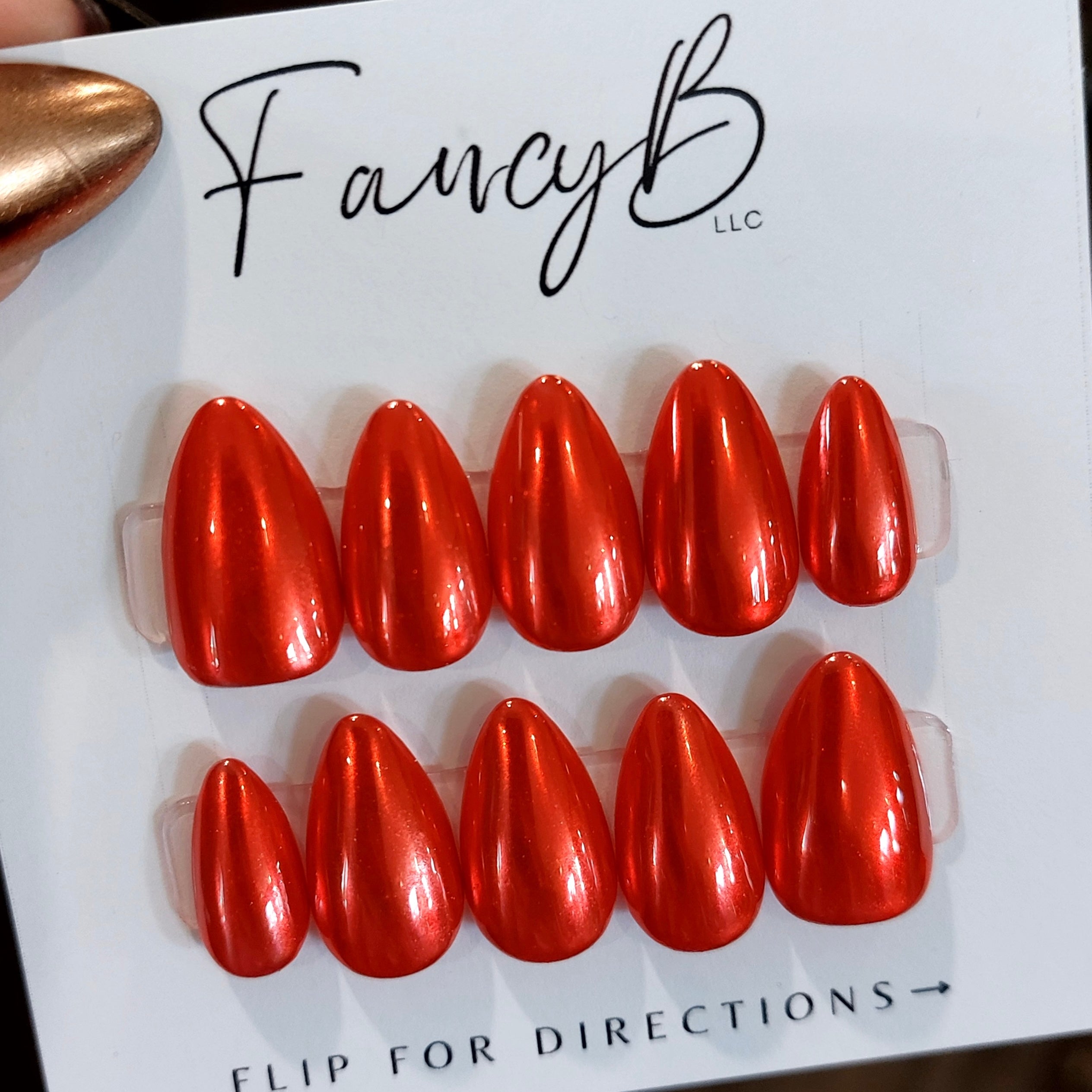 Custom chrome press on nails in bright red chrome with short almond shape. FancyB Nails.
