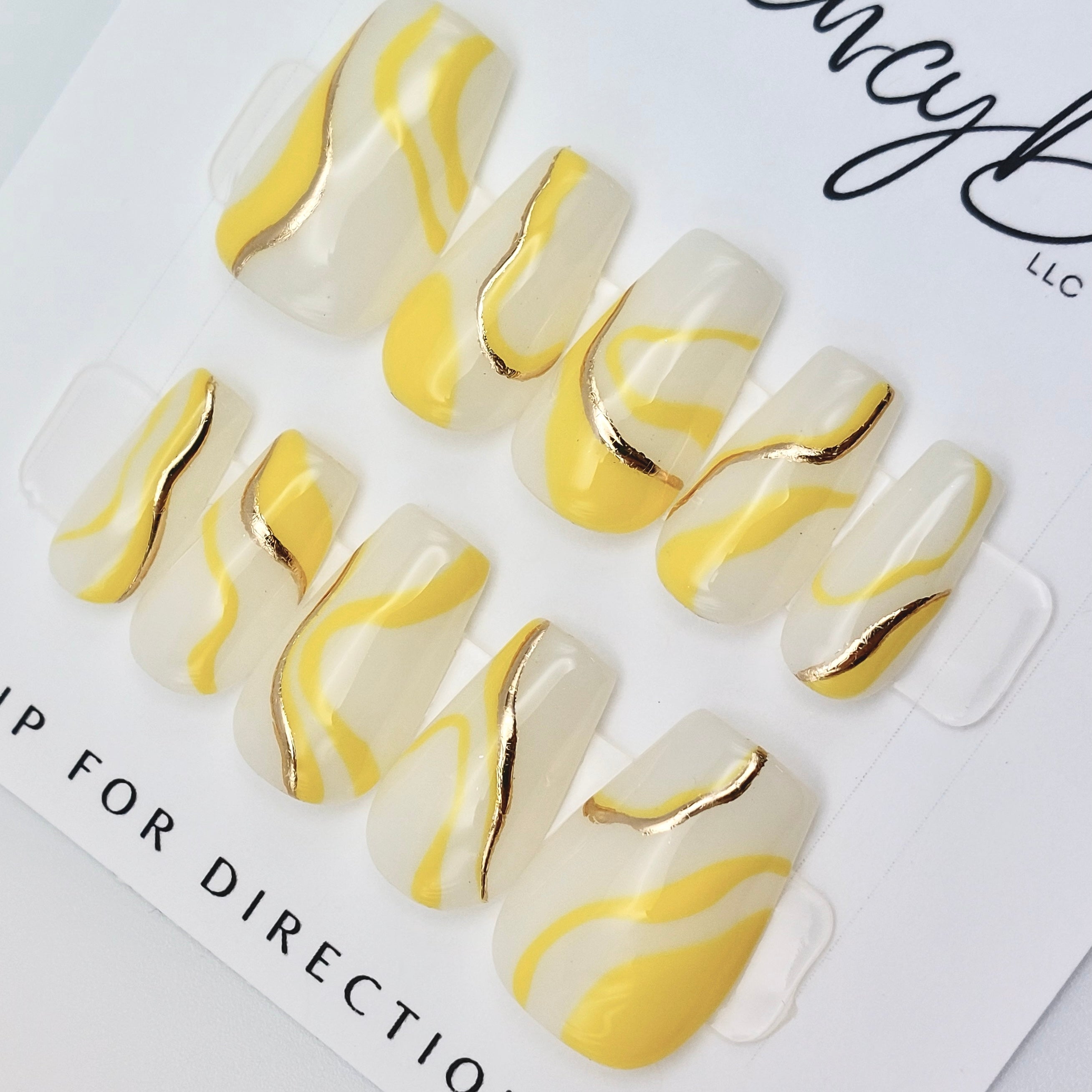fancyb custom press on nails milky white with yellow and gold chrome swirls on short coffin nail shape.