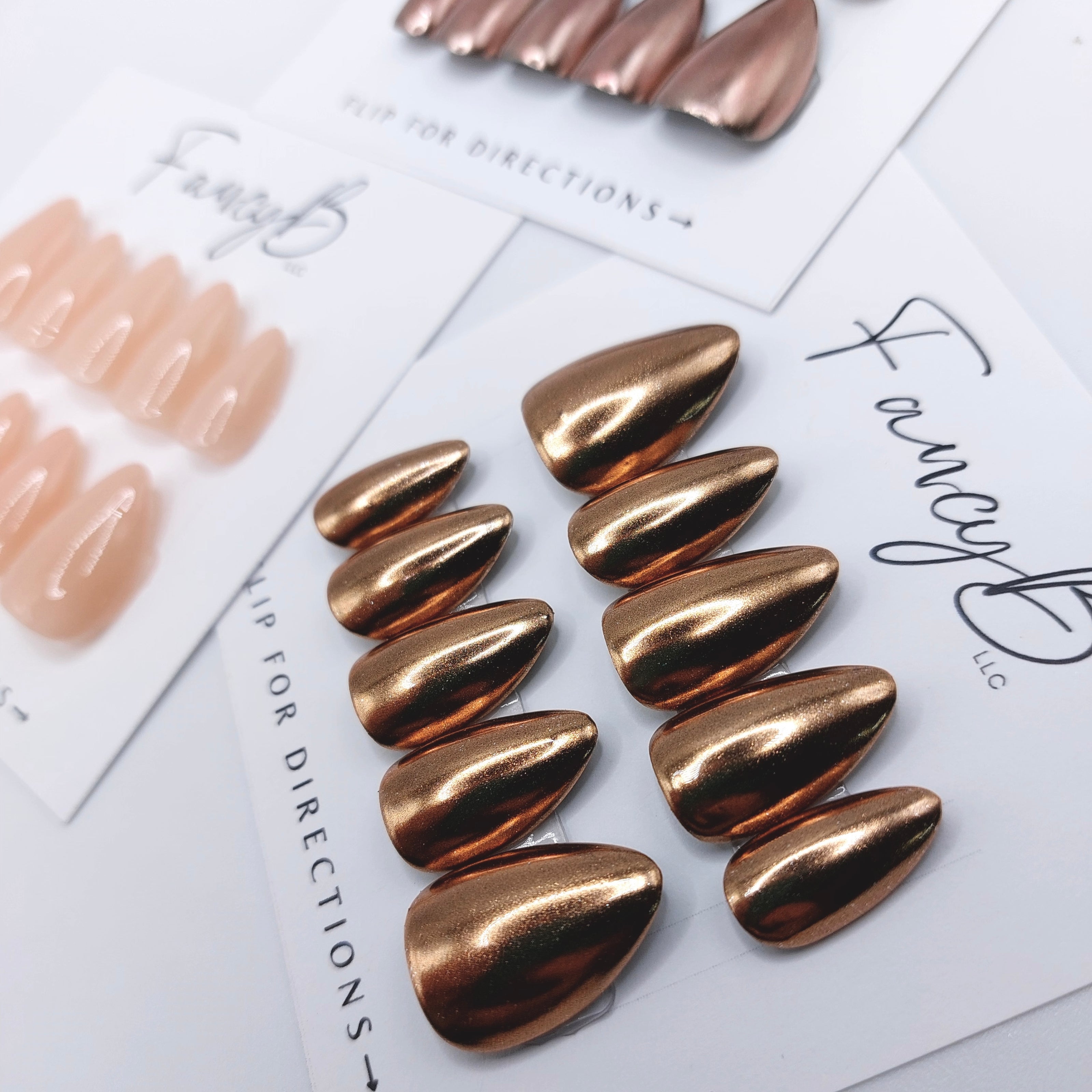 Chrome press on nails, champagne chrome and rose gold chrome in short almond shape. FancyB Nails.