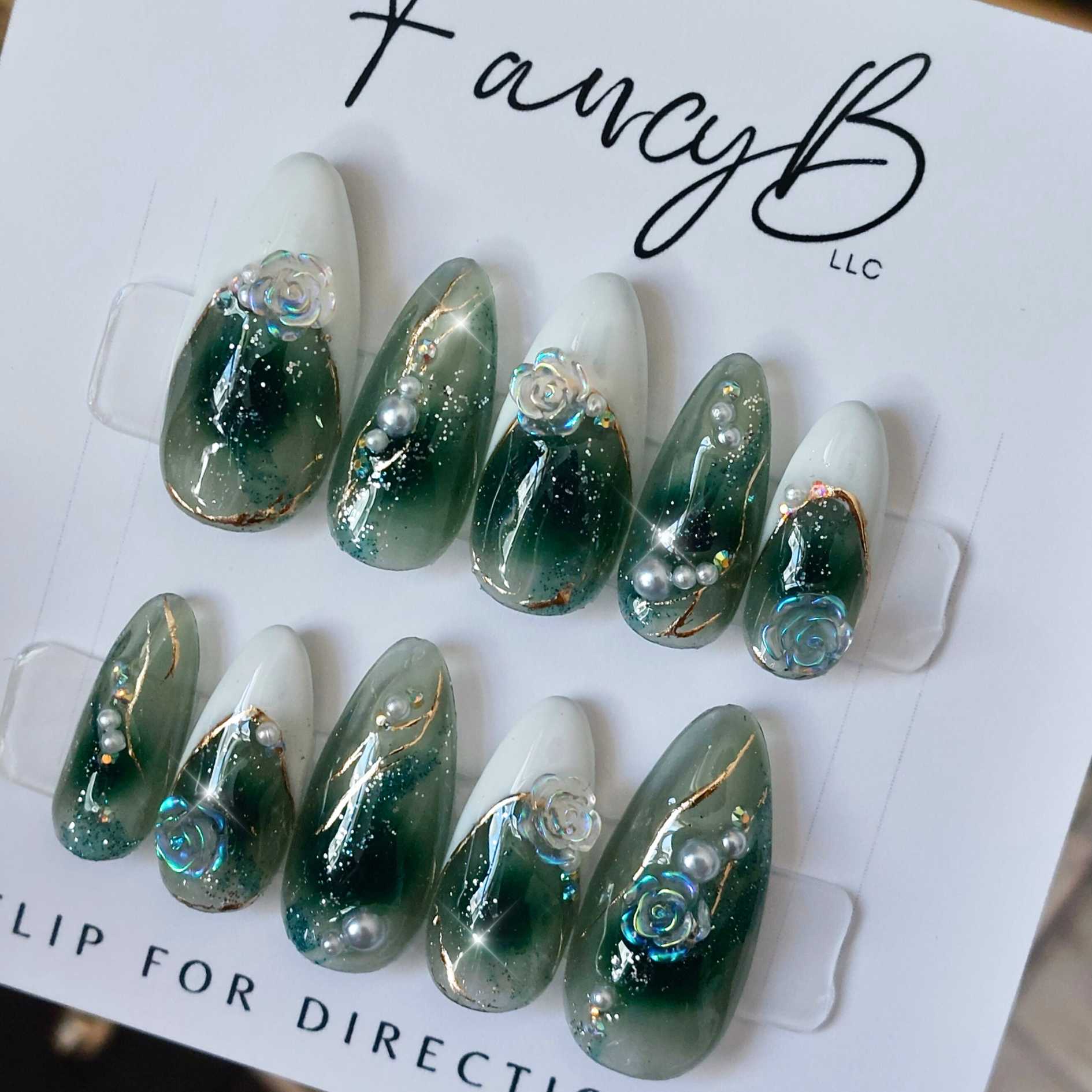 Custom emerald green press on nails, emerald green jelly nails with shimmer glitter, gold chrome lines, 3d crystal florals, flowers and pearls on a long almond shape by FancyB Nails.