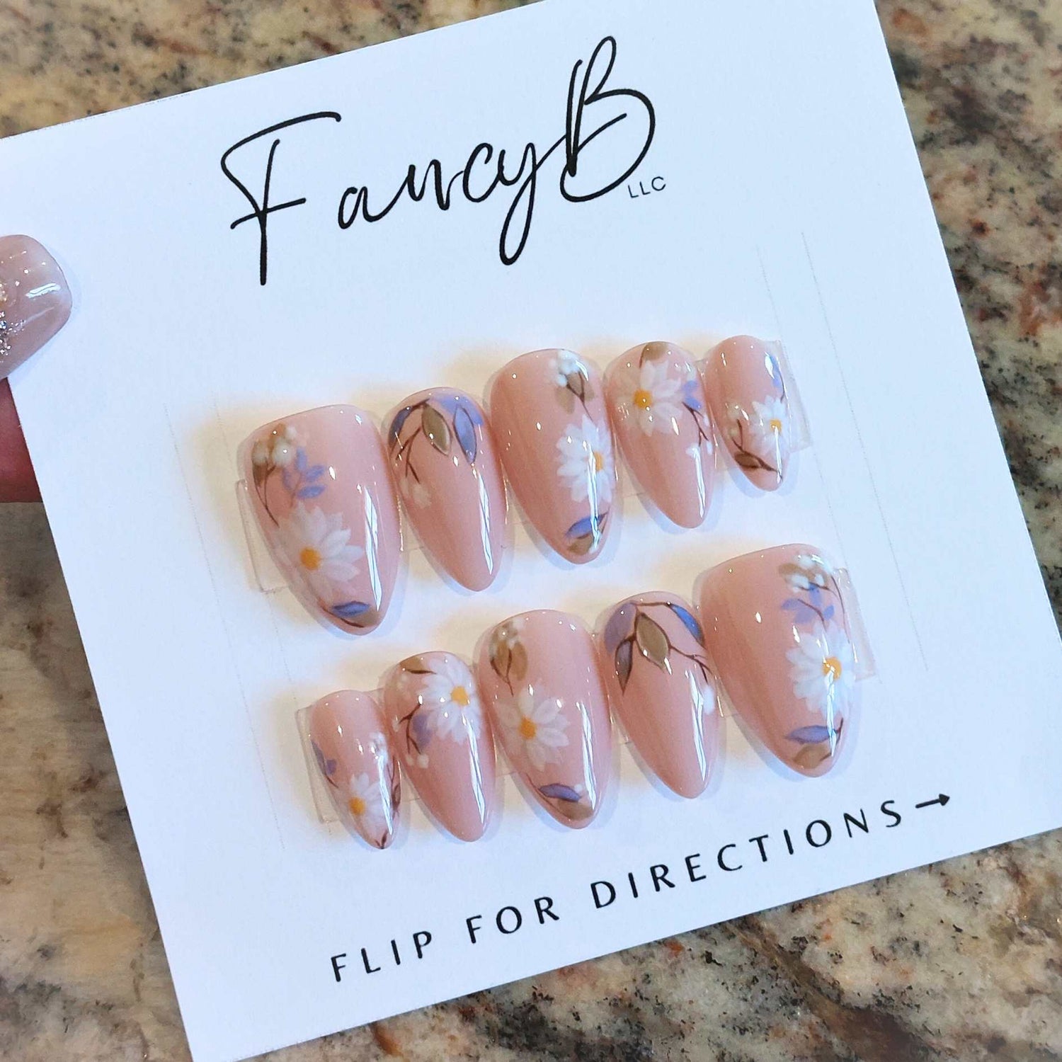 Custom floral nails with flowers, daisies, nude pink background and leaves on short almond shape, spring press on nails from fancyb nails
