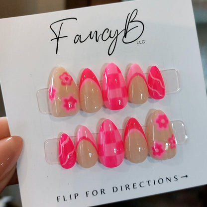Custom press on nails, hot pink checker board pattern with pink french tips and pink swirls in short almond shape. FancyB Nails.