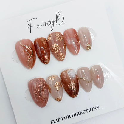 Fancy Floral press on nails, flower press on nails with gold and champagne flowers, pink merlot marble designs with glitter and champagne accents. Handmade reusable press on nails from FancyB Nails in short almond.