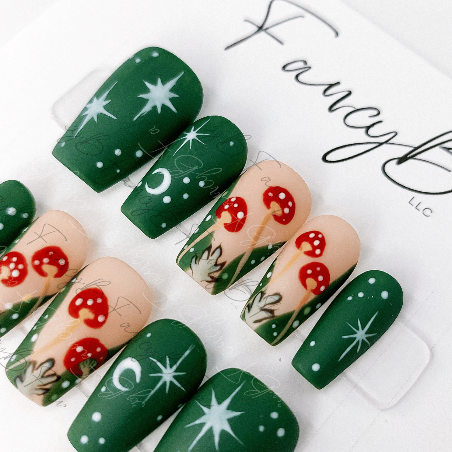 Custom press on nails mushroom leafy nails with green celestial designs. Hand painted mushroom nails in short coffin shape from FancyB Nails.