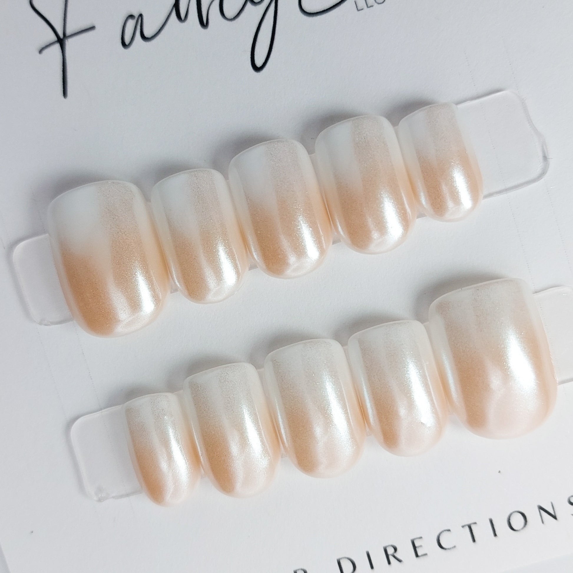 hailey b ombre press on nails, chrome glaze nails in nude to white. Short square, short squoval nail shape.