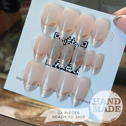 24 piece press on nail set, backside. Pearlescent French Tip Press on Nails with Gold Line on Nude base color, medium almond. Handmade press on nails from FancyB Nails.