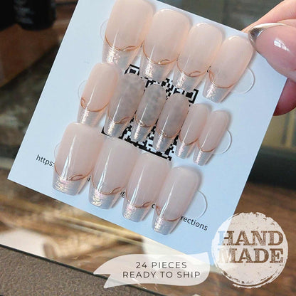 24 piece press on nail set, backside. Pearlescent French Tip Press on Nails with Gold Line on Nude base color, medium coffin. Handmade press on nails from FancyB Nails.