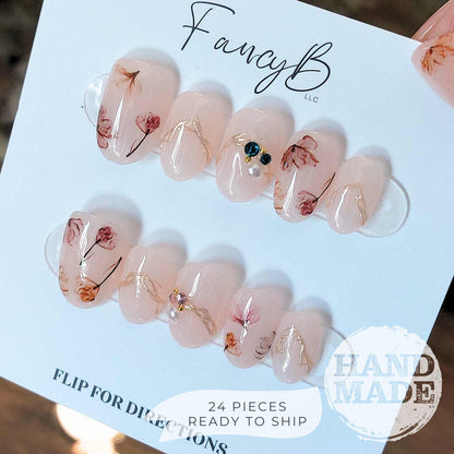 Floral press on nails, flower nails with dainty flowers, colorful gems, watercolor florals, and gold accents. FancyB handmade nails in short oval.