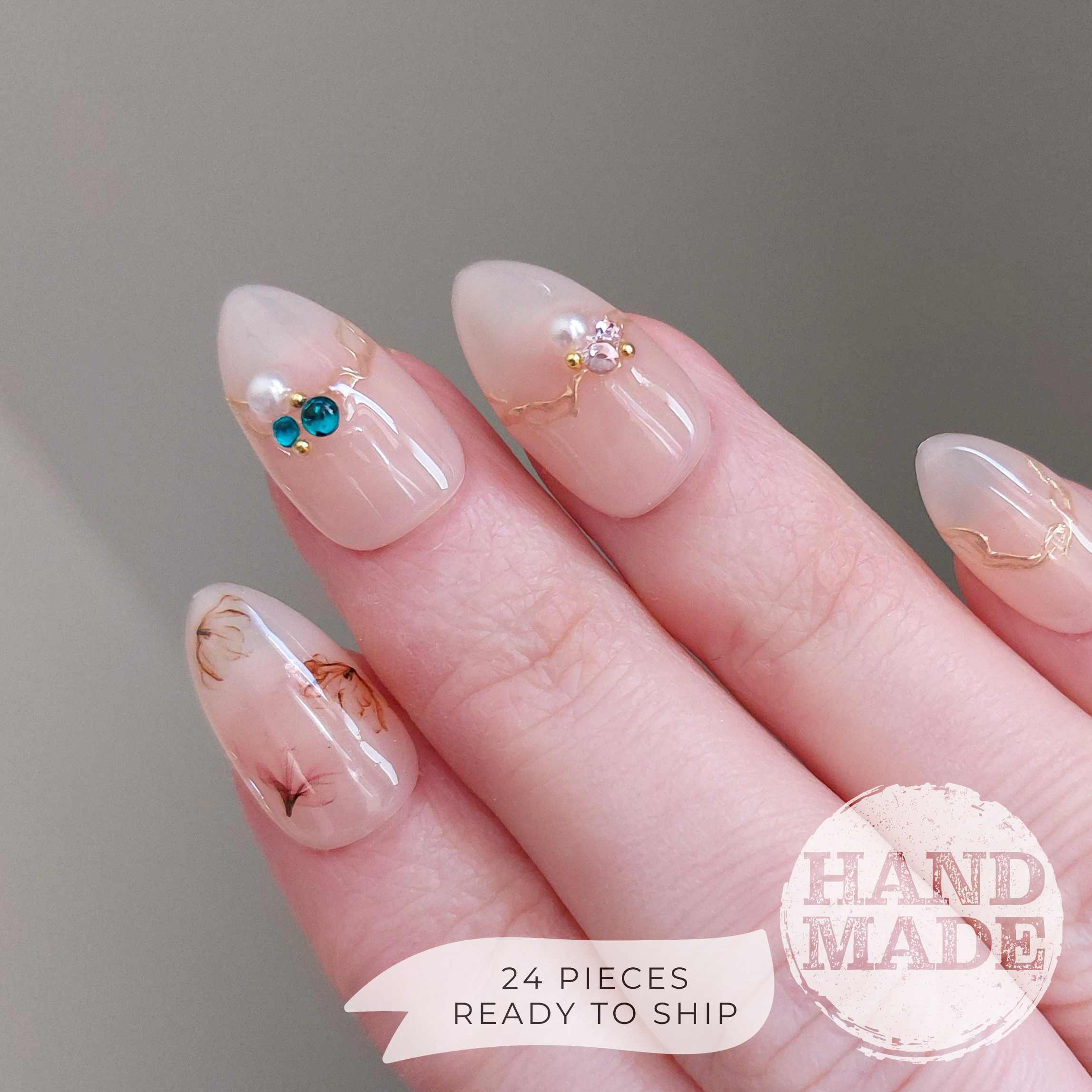 Floral press on nails, flower nails with dainty flowers, colorful gems, watercolor florals, and gold accents. FancyB handmade nails in short almond.