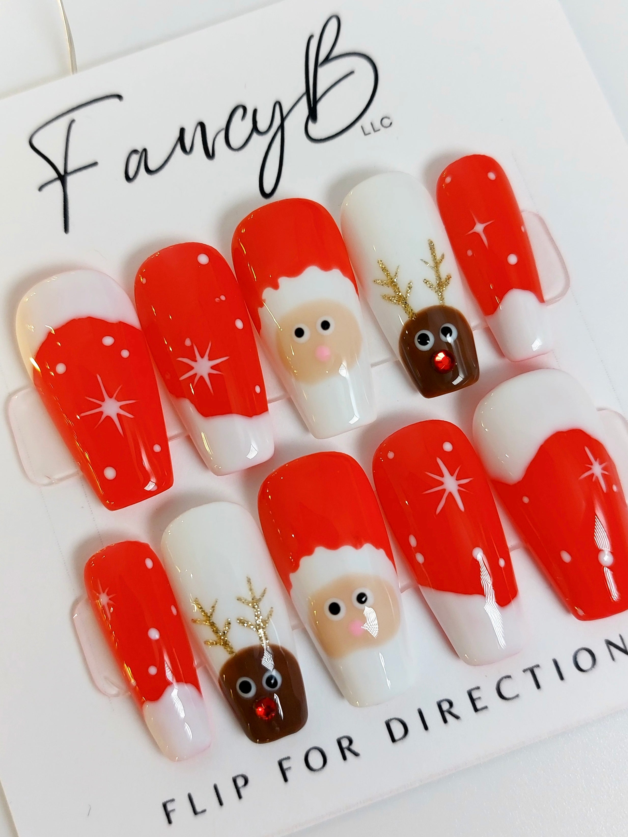 Custom Christmas Press on Nails, reindeer and santa accents with red background and snow designs. FancyB Nails.