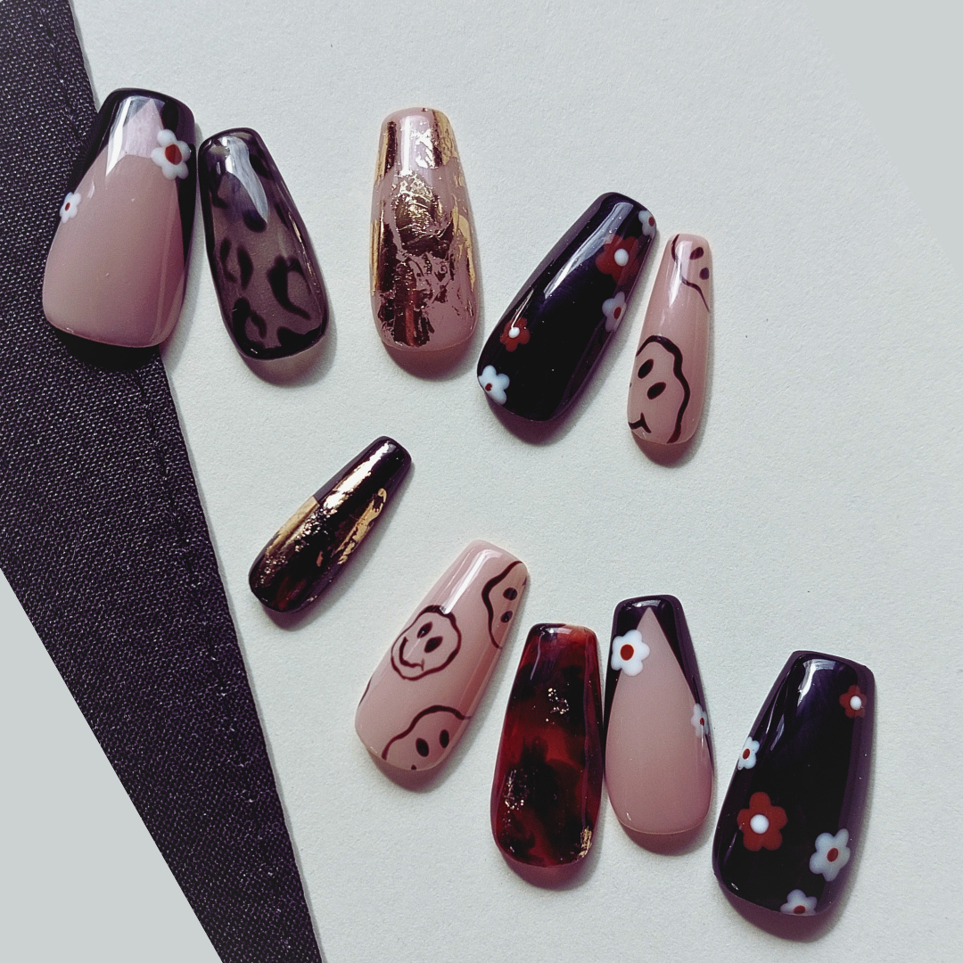 retro press on nails with smiley faces, tortoiseshell, leopard, flowers, black, nude, and gold flakes.