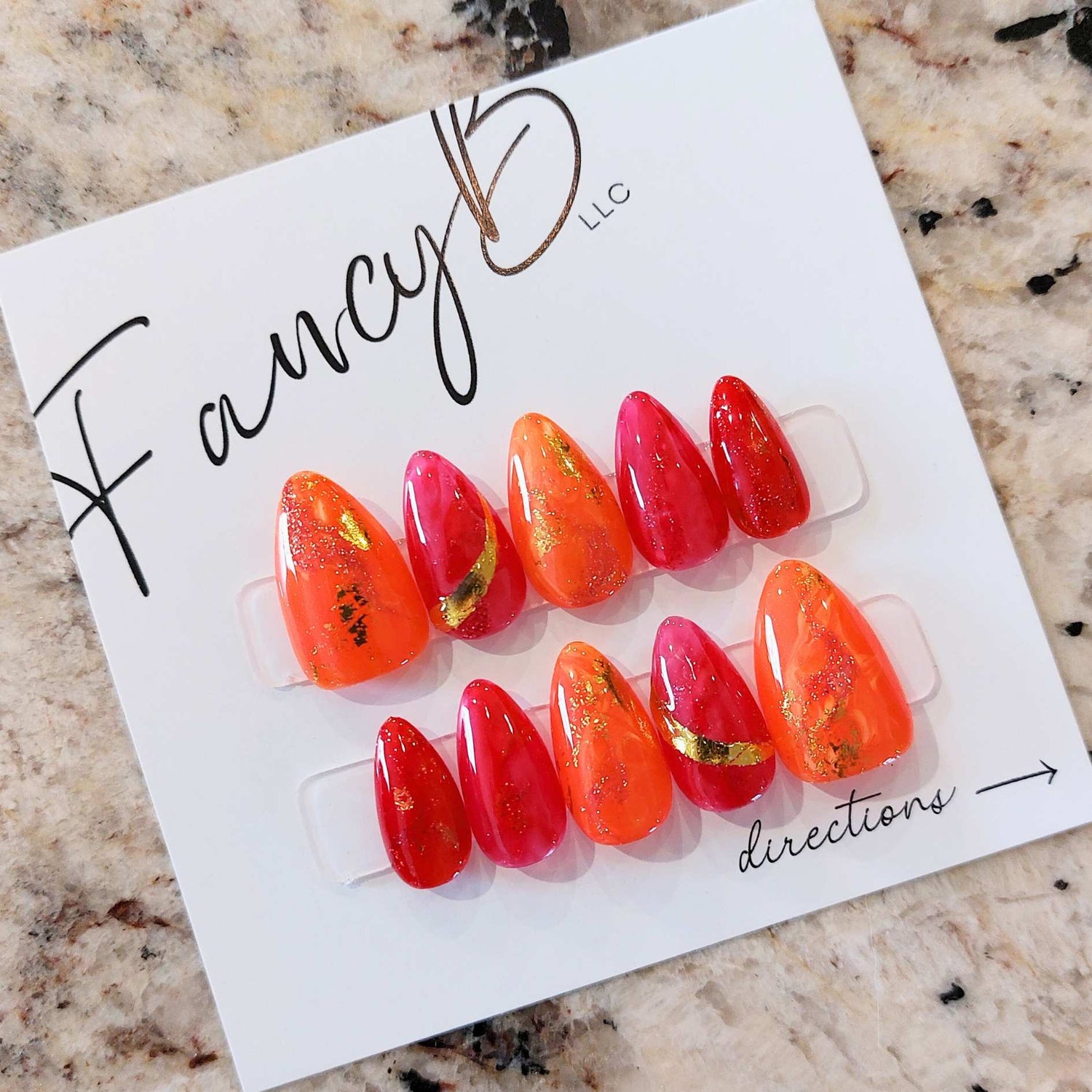 custom marble nails with bright orange and hot pink jelly colors with gold flakes on a short almond nail shape from fancyb custom press on nails