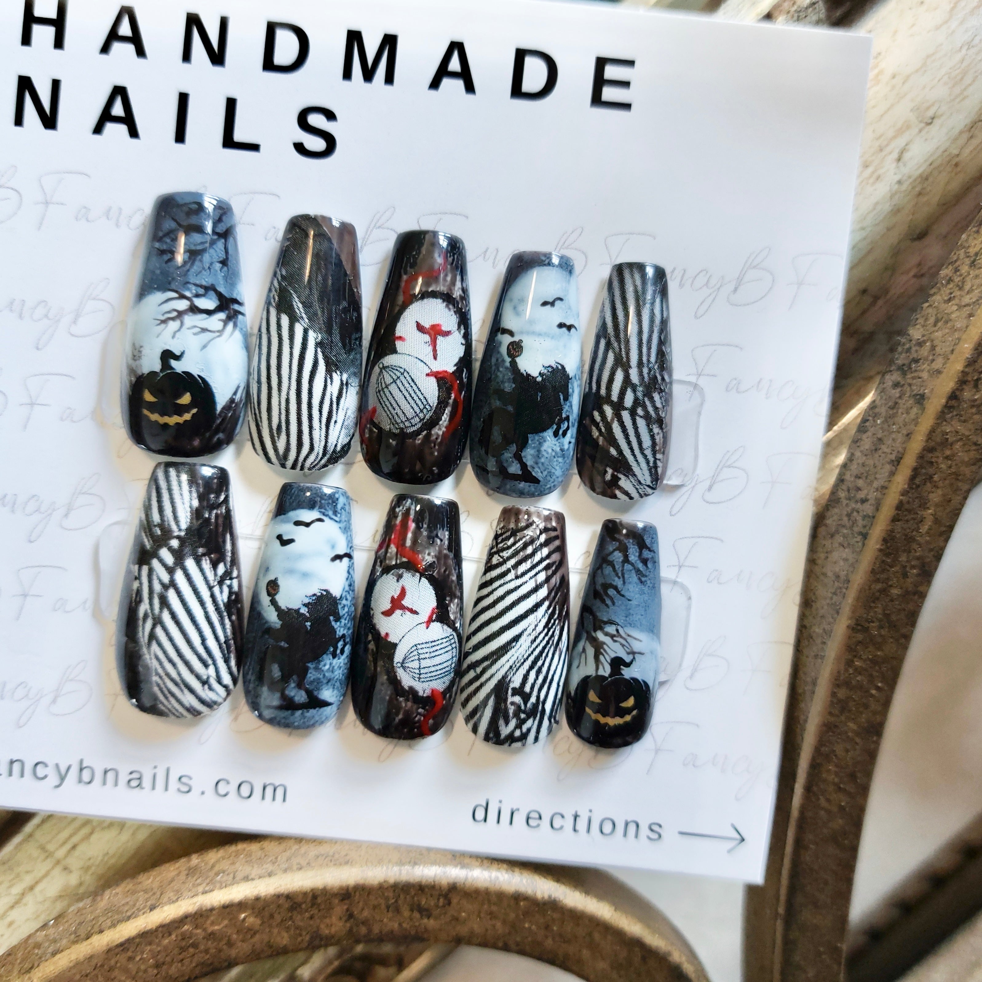 sleepy hollow nails tim burton theme nails with spooky theme, black and white stripes, jack-o-lantern, headless horseman, and bats on coffin nails