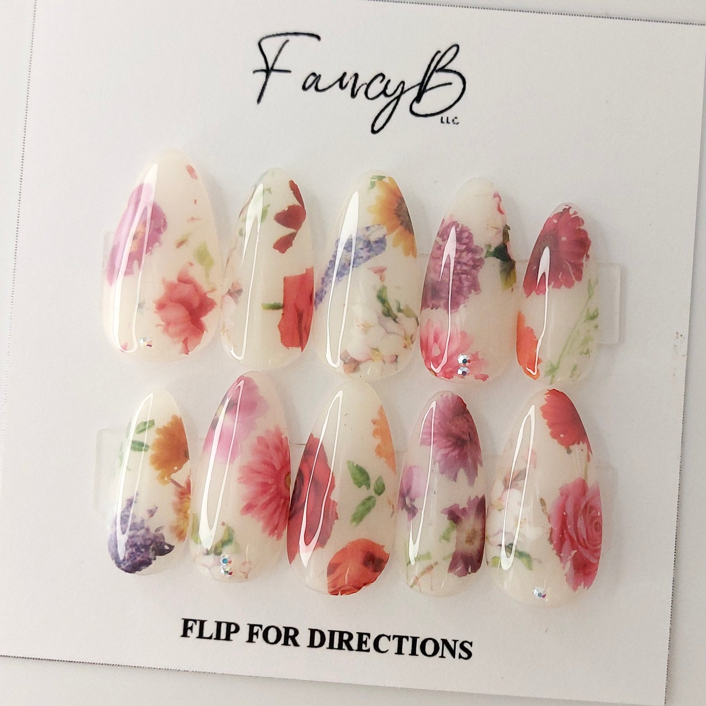 Milky Floral Press on Nail design adorned by some truly realistic flower designs in a long almond shape. Spring and easter nails. Perfect for weddings!