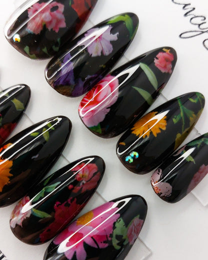 Black milk bath press on nails, colorful florals on a black background with a thin layer of black jelly and topped with crystal gems. Flower nails in long almond shape.