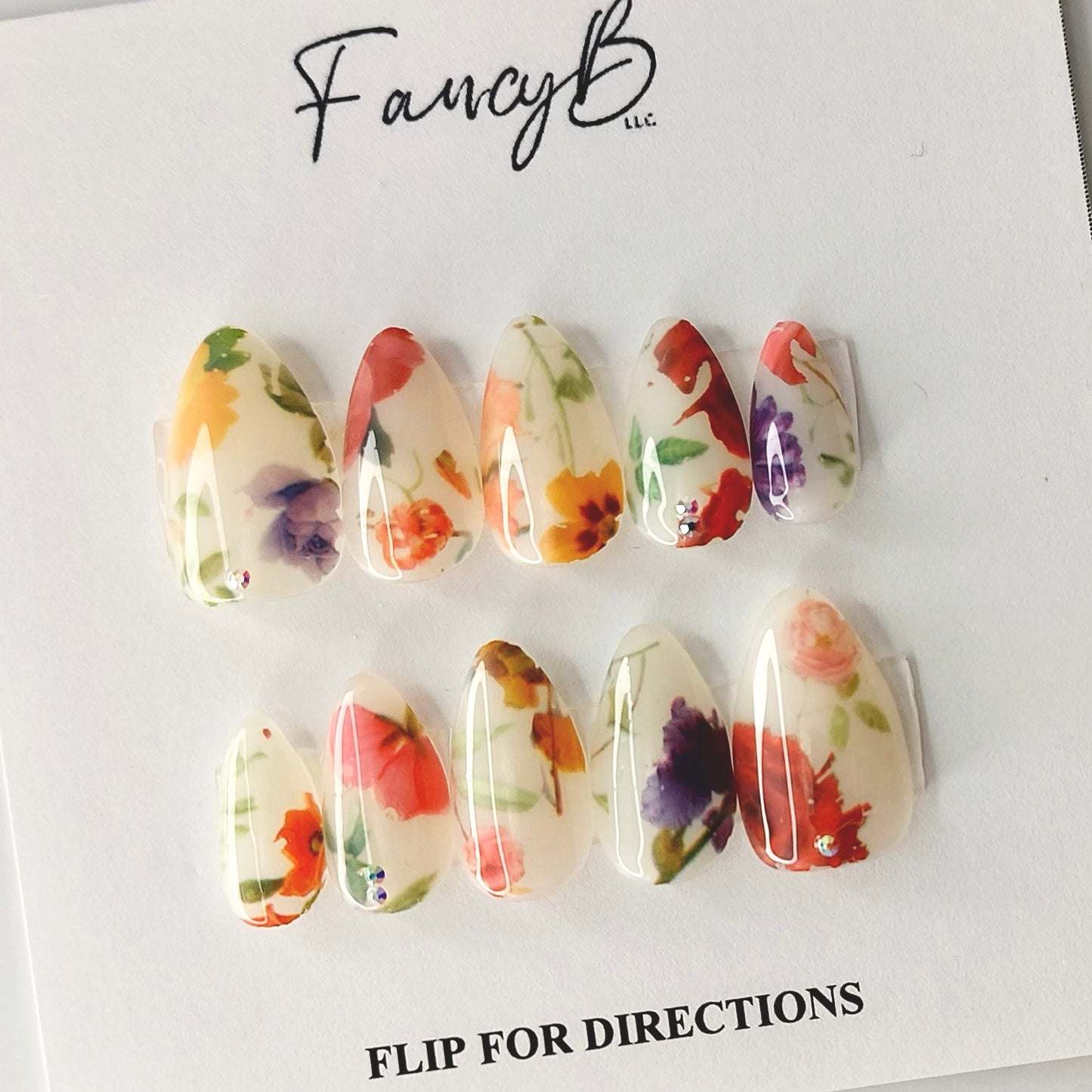 Milky Floral Press on Nail design adorned by some truly realistic flower designs in a short almond shape