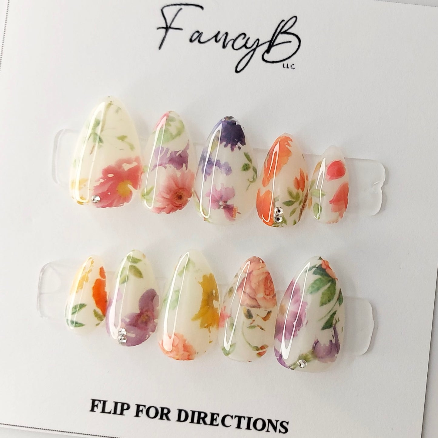 Milky Floral Press on Nail design adorned by some truly realistic flower designs in a short almond shape. Spring and easter nails.
