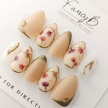 Japanese nail art press on nails with watercolor flowers on a nude background, with metallic accents and rose gold gems.