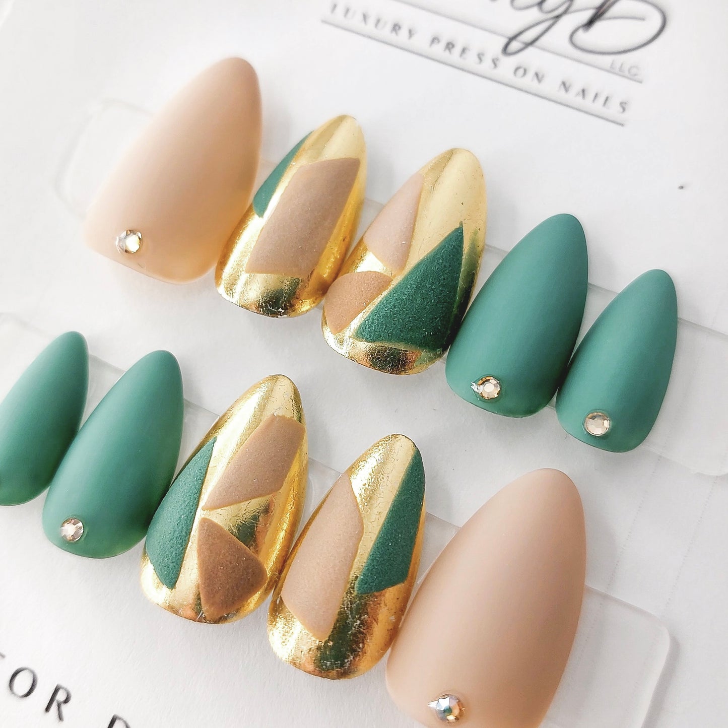 custom press on nails with color block beige and teal with gold chrome and geometric designs. Matte finish on short almond shape.