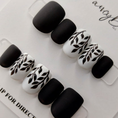 Custom press on nails. Black and white hand painted leaf nails with matte finish, a custom design that embodies elegance and simplicity, hand painted leaves finished in gloss.