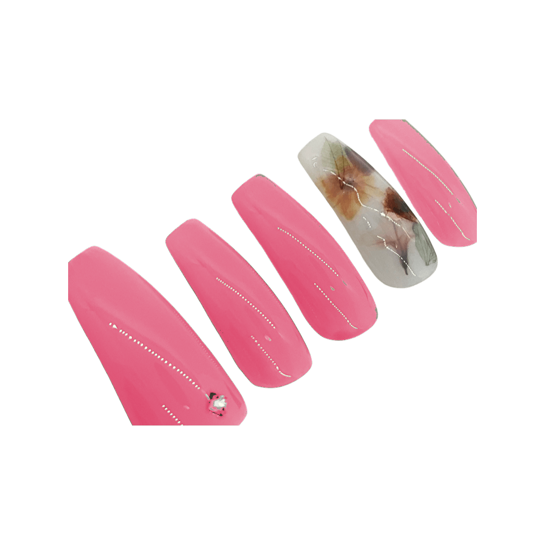 Ruby pink milk bath press on nails with a milky white accent nail with leaves and flowers. Shown in a long coffin/ballerina shape.