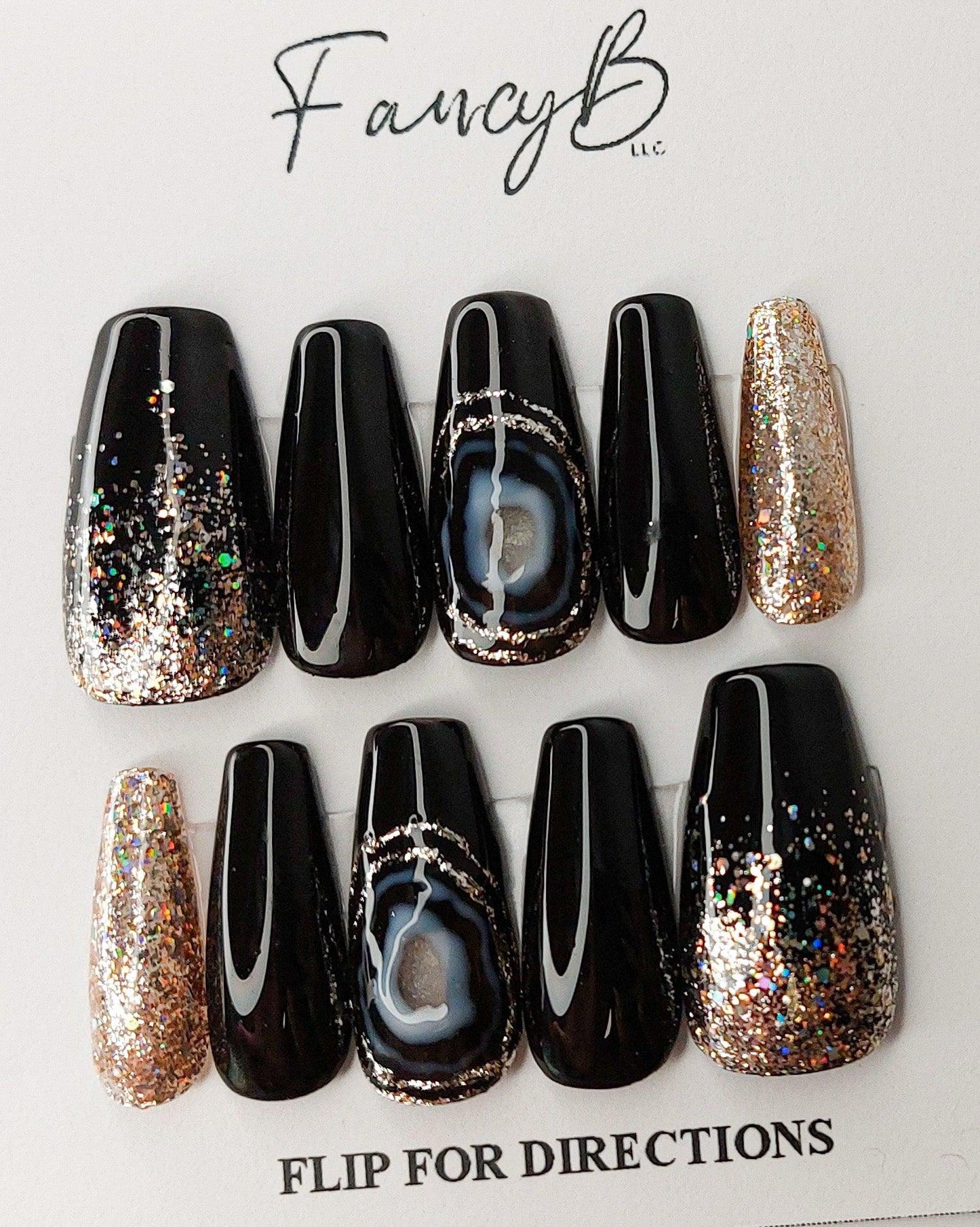 black agate press on nails with black nails and gold glitter, shown on medium coffin nails.